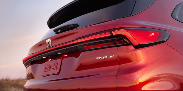 Buick rear design: Striking red SUV with a sleek horizontal taillight bar and modern tri-shield logo.