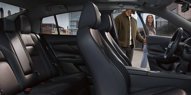 2026 Nissan Sentra interior side view spacious seating far doors open man near driver door.