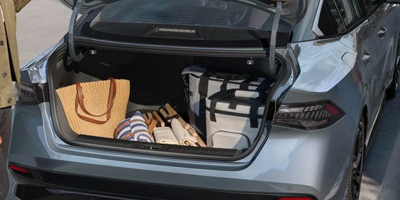 2026 Nissan Sentra view spacious easy load trunk woman loading suitcases.