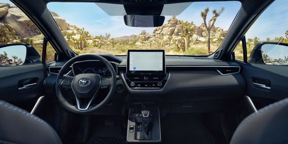 Toyota SUV interior: Modern black cockpit with a floating touchscreen, set against the rugged Joshua Tree desert landscape.