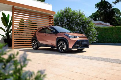 Aygo X parked outside a modern house