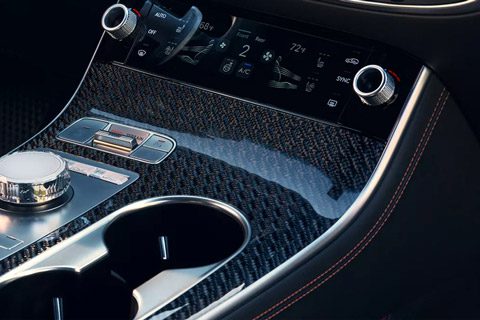 2026 Genesis GV70 interior close-up showing steering wheel, infotainment screen, and center console