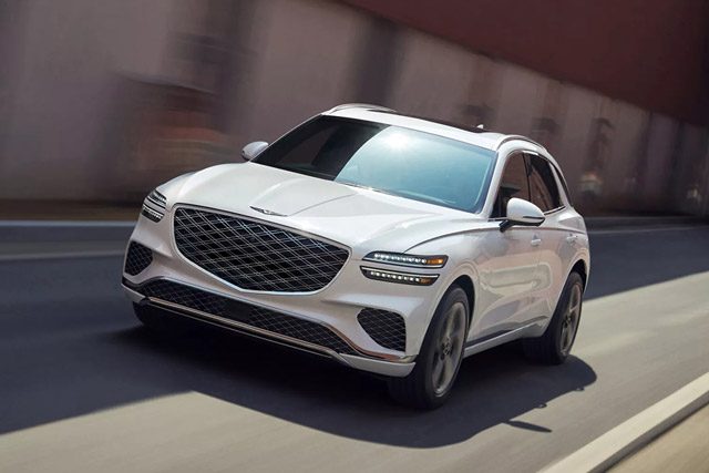 Front view of a white Genesis GV70 speeding down a road