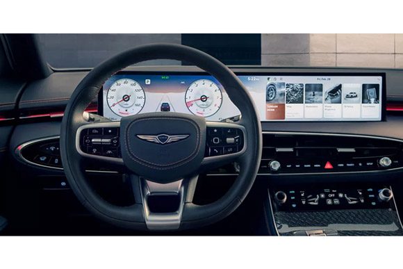Interior driver seat pov close-up of 2026 Genesis GV70 D-cut steering wheel and digital dashboard