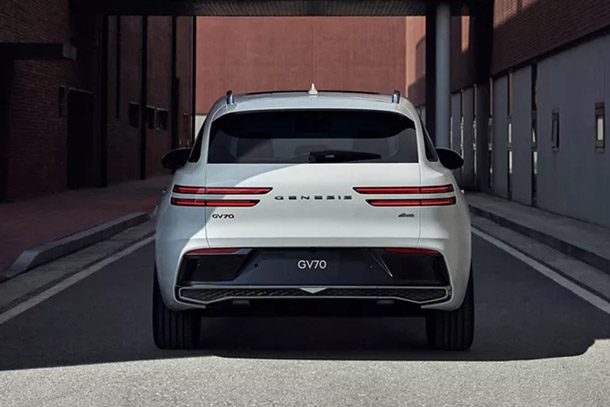 Rear view of a white Genesis GV70 parked on a side street