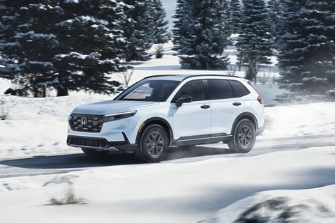 2026 Honda CR-V TrailSport in Platinum While Pearl driving on a snowy road