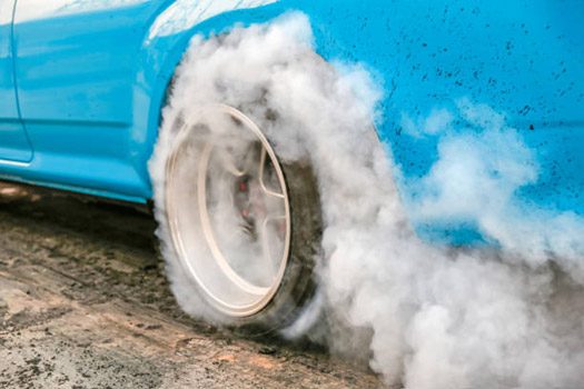 Car tires smoking from friction in hot weather
