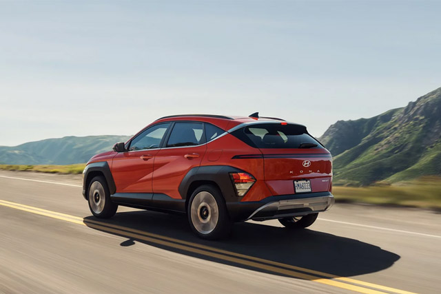 Rear three-quarter view of the 2026 Hyundai Kona Limited in Orange Pearl