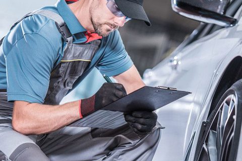 Workers are performing routine maintenance on the cars