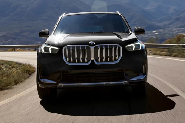 Front view of an 2026 BMW X1 driving on a curvy road