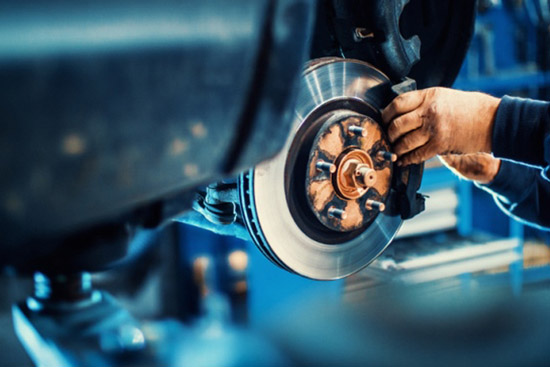 Technician repairing car brake system