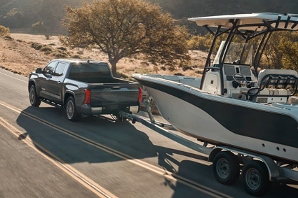 A black 2026 Toyota Tundra towing a small boat